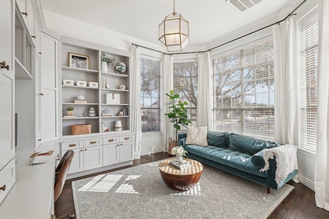 living area featuring visible vents, a healthy amount of sunlight, crown molding, and dark wood-type flooring