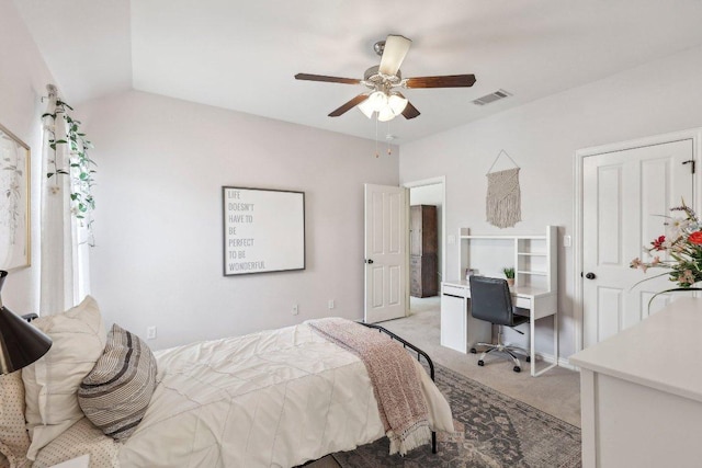 bedroom with visible vents, light colored carpet, a ceiling fan, and vaulted ceiling