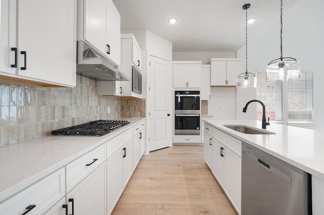 1601 Cardinal Ln, Round Rock, TX 78681 - kitchen with a sink, stainless steel appliances, under cabinet range hood, white cabinetry, and hanging light fixtures