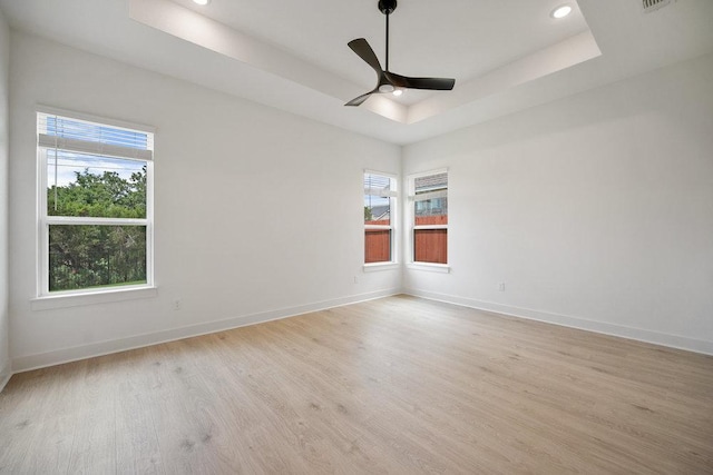 1601 Cardinal Ln, Round Rock, TX 78681 - spare room with a tray ceiling, light wood finished floors, healthy amount of natural light, baseboards, and recessed lighting