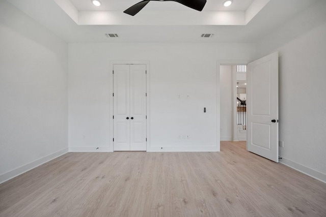 1601 Cardinal Ln, Round Rock, TX 78681 - unfurnished bedroom featuring a tray ceiling, light wood finished floors, baseboards, a closet, and recessed lighting