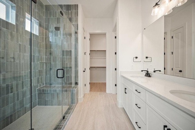 1601 Cardinal Ln, Round Rock, TX 78681 - bathroom featuring a stall shower, double vanity, and a walk in closet