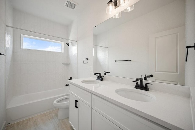 1601 Cardinal Ln, Round Rock, TX 78681 - full bathroom with toilet, double vanity, shower / bath combination, and wood finished floors