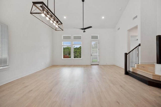 1601 Cardinal Ln, Round Rock, TX 78681 - unfurnished living room with stairs, wood finished floors, baseboards, high vaulted ceiling, and recessed lighting