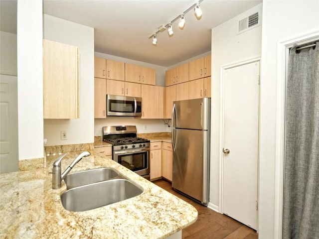 2209 Hancock Dr Unit 4, Austin, TX 78756 - kitchen with stainless steel appliances, light brown cabinets, a sink, and dark wood-style flooring