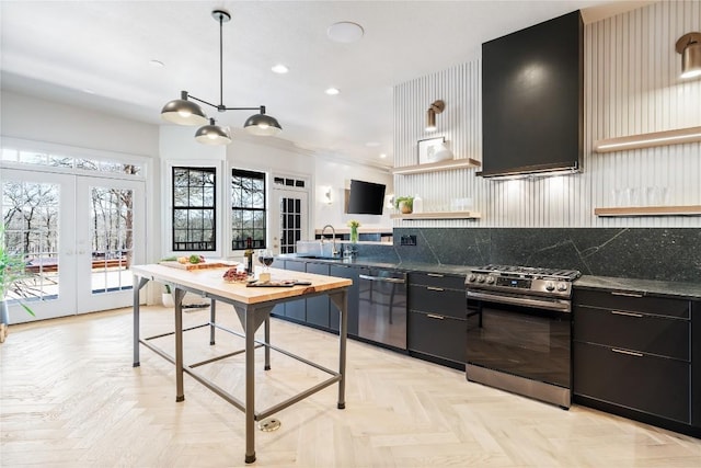 kitchen featuring dark countertops, a sink, open shelves, stainless steel appliances, and dark cabinets
