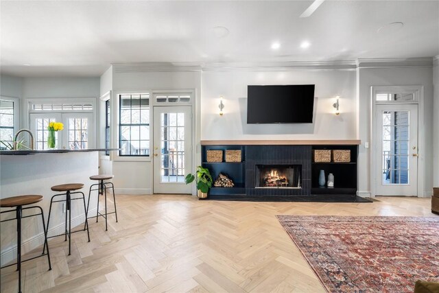 living room featuring plenty of natural light, crown molding, and baseboards