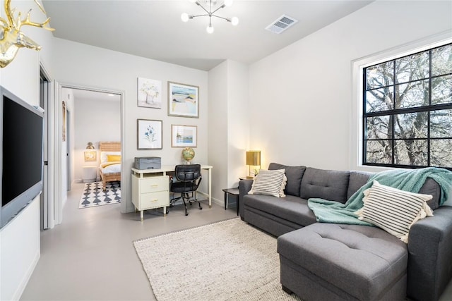 living room featuring baseboards, visible vents, finished concrete flooring, and an inviting chandelier