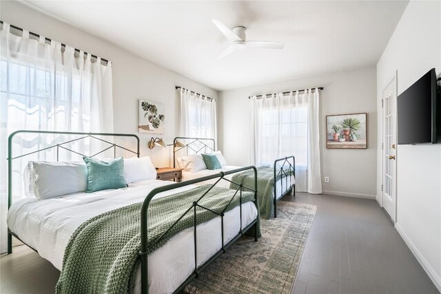 bedroom with a ceiling fan, baseboards, and wood finished floors