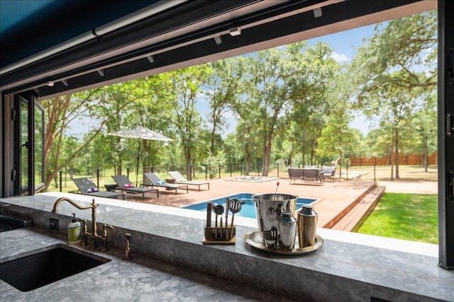 view of patio featuring a fenced in pool, a fenced backyard, and a sink