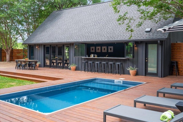 view of pool featuring fence, a fenced in pool, outdoor dry bar, and a wooden deck