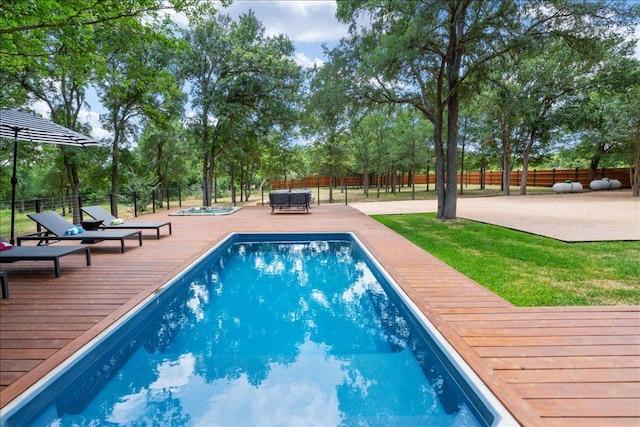 view of pool featuring a wooden deck and fence