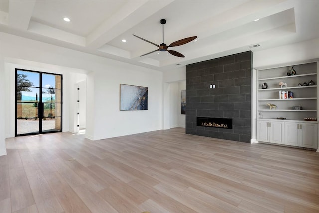 3113 Stableford Cv, Spicewood, TX 78669 - unfurnished living room featuring ceiling fan, light wood finished floors, recessed lighting, a tiled fireplace, and beam ceiling