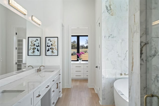 3113 Stableford Cv, Spicewood, TX 78669 - full bathroom with double vanity, a soaking tub, a marble finish shower, and wood finished floors