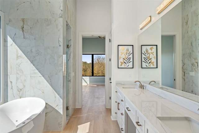 3113 Stableford Cv, Spicewood, TX 78669 - full bathroom featuring wood finished floors, a freestanding bath, double vanity, and a marble finish shower