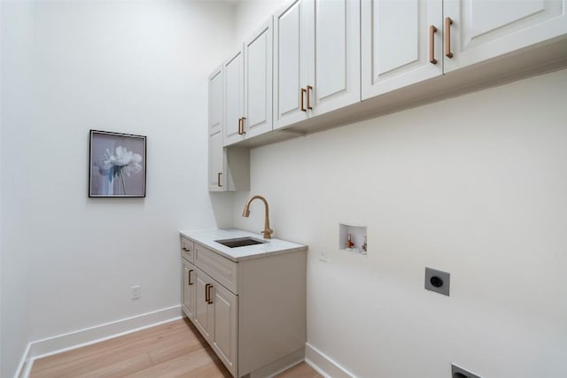 3113 Stableford Cv, Spicewood, TX 78669 - washroom with electric dryer hookup, cabinet space, light wood-style floors, and hookup for a washing machine
