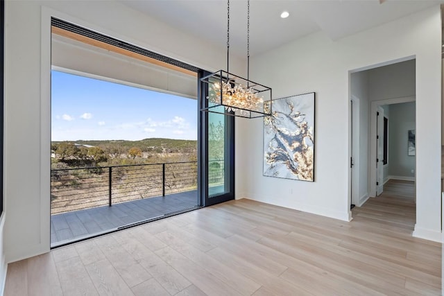 3113 Stableford Cv, Spicewood, TX 78669 - unfurnished dining area with wood finished floors, plenty of natural light, and a chandelier
