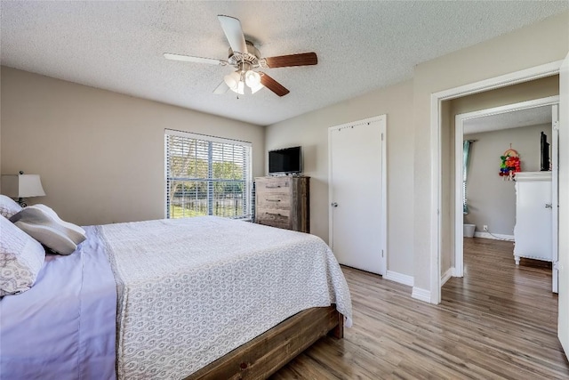 21500 Bluejay Blvd, Lago Vista, TX 78645 - bedroom with a textured ceiling, wood finished floors, and a ceiling fan