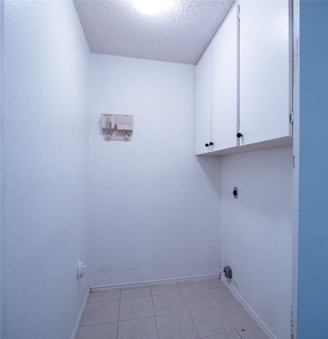 3379 S El Dorado, Lakeway, TX 78734 - laundry area with cabinet space, hookup for an electric dryer, a textured ceiling, light tile patterned floors, and baseboards