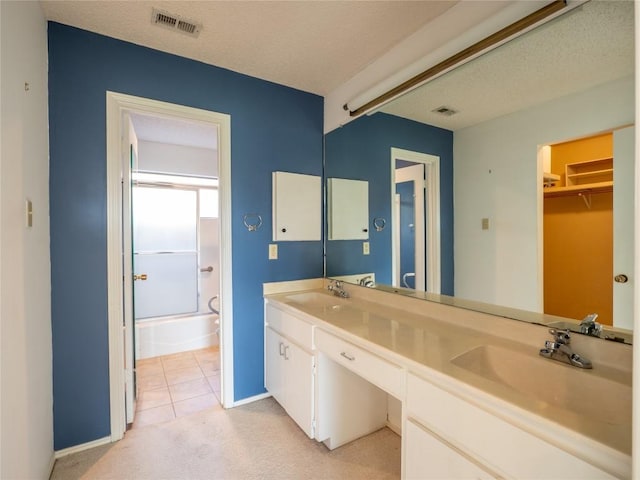 3379 S El Dorado, Lakeway, TX 78734 - full bathroom with double vanity, a textured ceiling, tile patterned floors, and a spacious closet