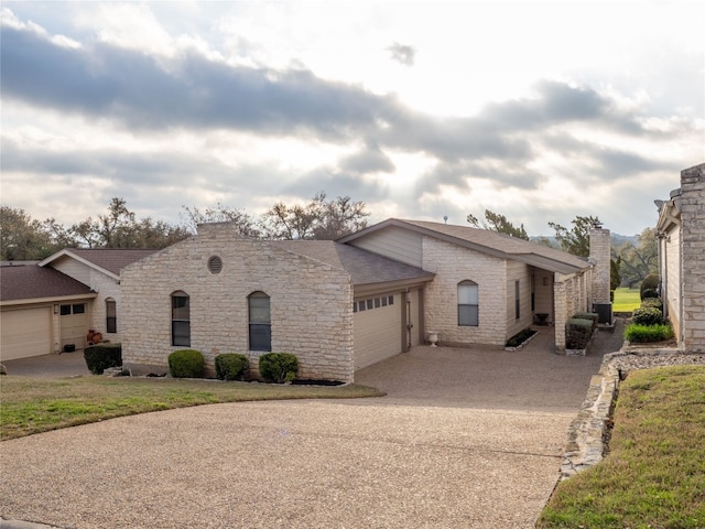3379 S El Dorado, Lakeway, TX 78734 - view of front of home featuring concrete driveway, an attached garage, central AC, a shingled roof, and stone siding