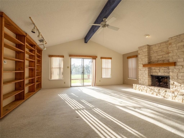3379 S El Dorado, Lakeway, TX 78734 - unfurnished living room featuring ceiling fan, a stone fireplace, carpet flooring, rail lighting, and a textured ceiling