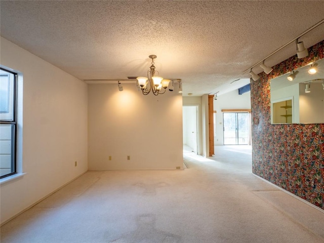 3379 S El Dorado, Lakeway, TX 78734 - carpeted empty room with rail lighting, a chandelier, and a textured ceiling