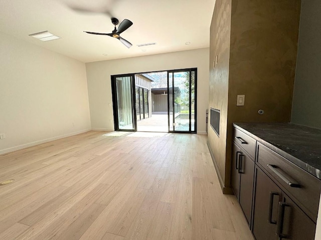 705 E 50th St, Austin, TX 78751 - unfurnished living room featuring visible vents, baseboards, light wood-style floors, and a ceiling fan