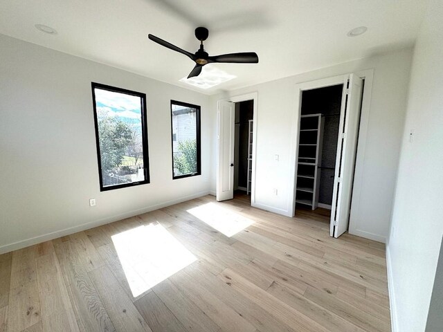 705 E 50th St, Austin, TX 78751 - unfurnished bedroom with baseboards, ceiling fan, two closets, and light wood-style floors