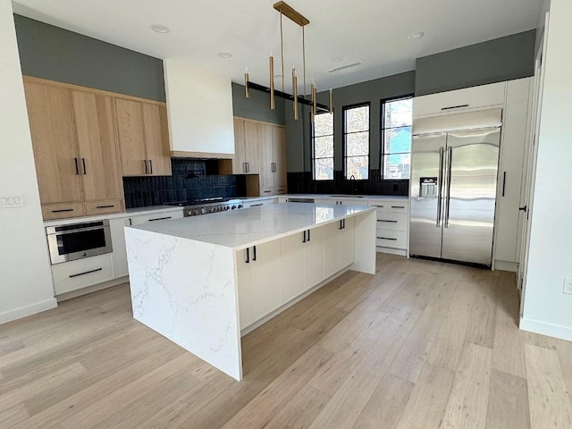 705 E 50th St, Austin, TX 78751 - kitchen with a center island, appliances with stainless steel finishes, modern cabinets, and wall chimney exhaust hood