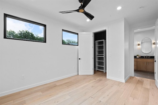 705 E 50th St, Austin, TX 78751 - unfurnished bedroom with a walk in closet, light wood-style flooring, recessed lighting, a closet, and a ceiling fan