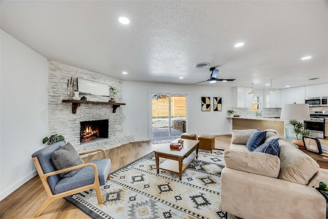 11704 Indianhead Dr, Austin, TX 78753 - living area featuring a fireplace, light wood finished floors, recessed lighting, a ceiling fan, and a textured ceiling