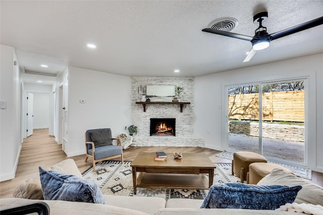 11704 Indianhead Dr, Austin, TX 78753 - living room featuring a fireplace, recessed lighting, light wood finished floors, a ceiling fan, and a textured ceiling