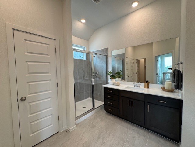 2705 Sage Ranch Dr Unit 26, Leander, TX 78641 - bathroom with vaulted ceiling, a shower stall, vanity, and tile patterned flooring