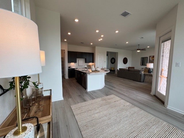 2705 Sage Ranch Dr Unit 26, Leander, TX 78641 - kitchen featuring open floor plan, light wood-style flooring, light countertops, recessed lighting, and a center island with sink