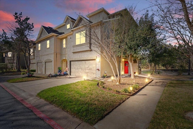 view of front of home with stucco siding, driveway, and a garage