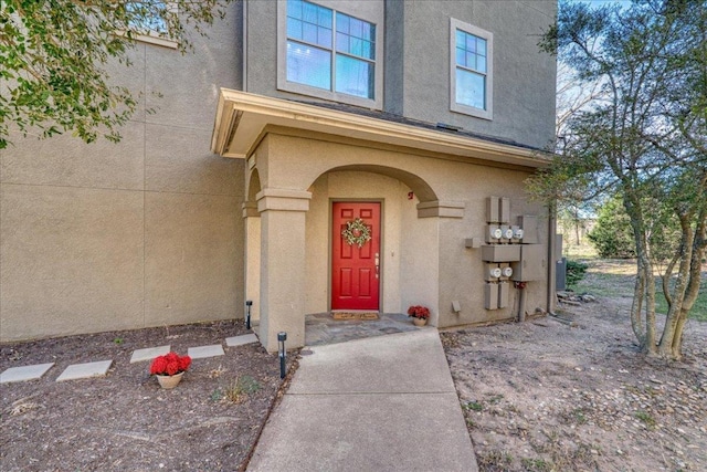 doorway to property featuring stucco siding