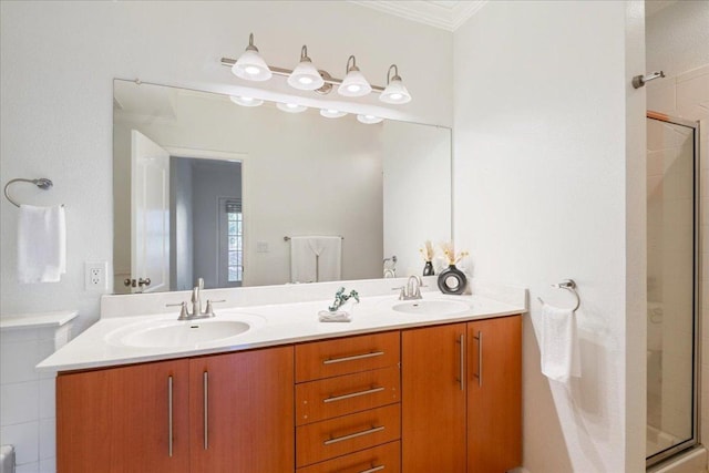 full bathroom featuring a shower stall, crown molding, and a sink