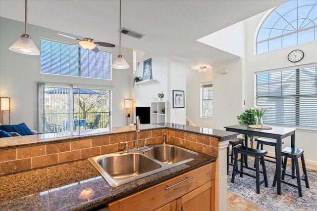 kitchen featuring a ceiling fan, a wealth of natural light, open floor plan, and a sink