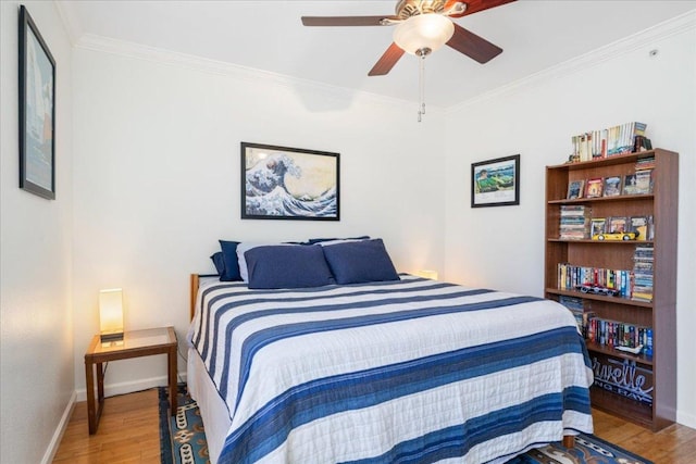 bedroom with baseboards, a ceiling fan, wood finished floors, and ornamental molding