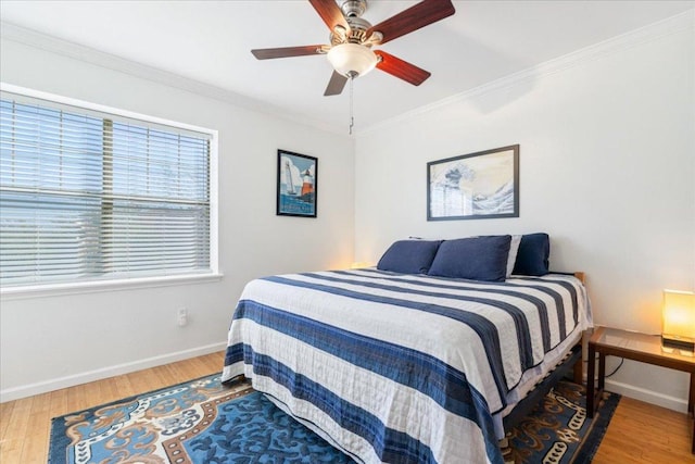 bedroom featuring baseboards, wood finished floors, and ornamental molding