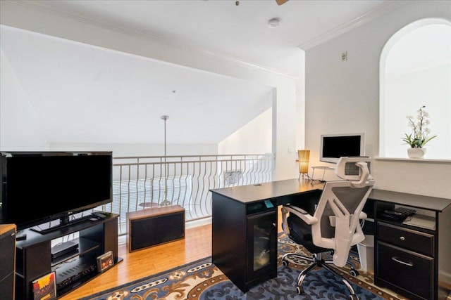 office area featuring crown molding, arched walkways, lofted ceiling, and wood finished floors