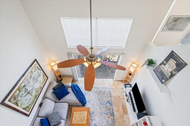 living area featuring a high ceiling and ceiling fan