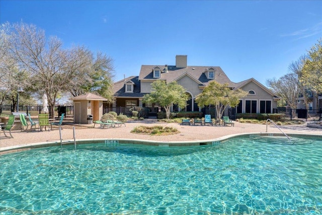 pool with a patio and fence