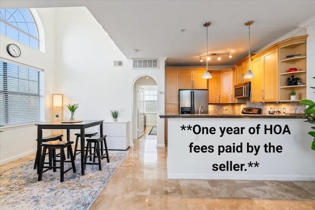 kitchen featuring visible vents, stainless steel appliances, open shelves, and arched walkways