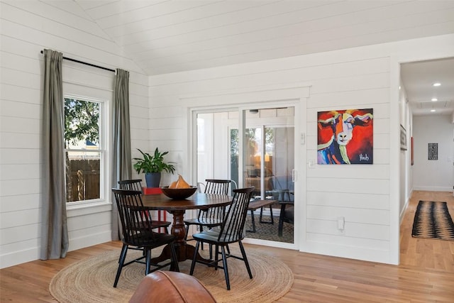 703 E 15th St, Georgetown, TX 78626 - dining room featuring healthy amount of natural light, light wood finished floors, lofted ceiling, and wood walls