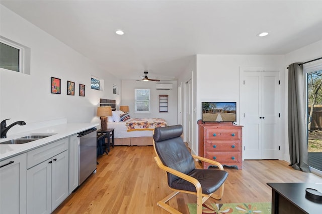 703 E 15th St, Georgetown, TX 78626 - bedroom featuring a sink, a wall mounted air conditioner, multiple windows, light wood-type flooring, and recessed lighting
