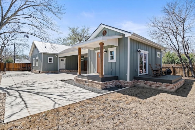 703 E 15th St, Georgetown, TX 78626 - back of house with covered porch, board and batten siding, and concrete driveway