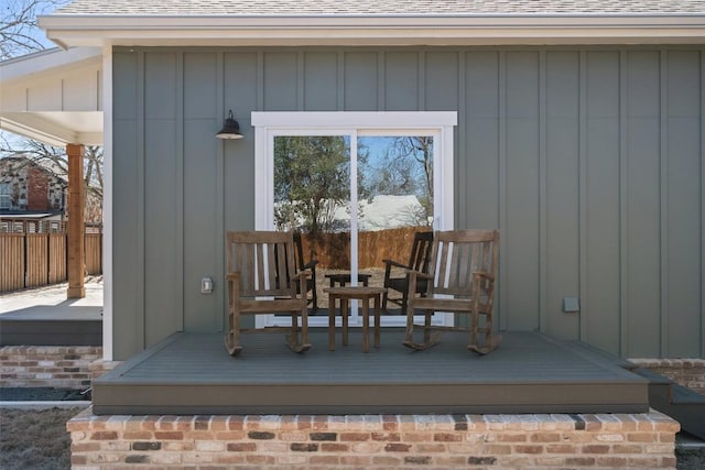 703 E 15th St, Georgetown, TX 78626 - property entrance with board and batten siding, a shingled roof, and a wooden deck