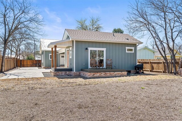 703 E 15th St, Georgetown, TX 78626 - back of property featuring a fenced backyard, a patio area, and a shingled roof
